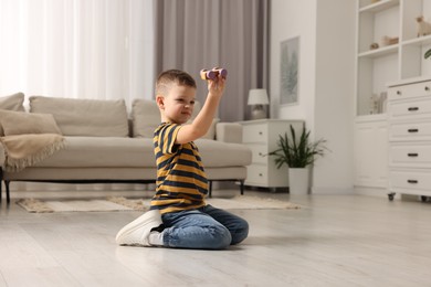 Photo of Little boy playing with toy car at home