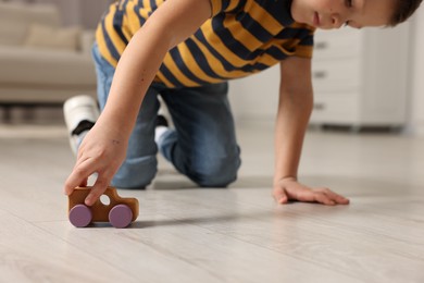 Photo of Little boy playing with toy car at home, closeup