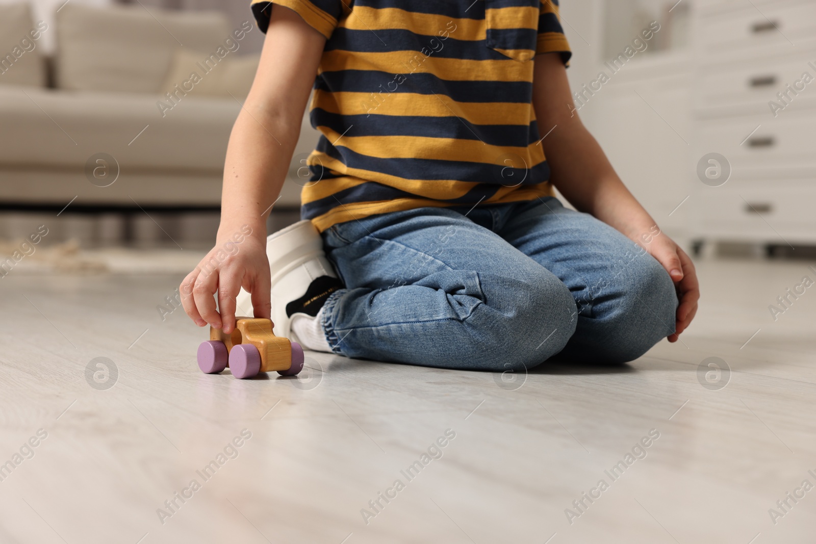 Photo of Little boy playing with toy car at home, closeup