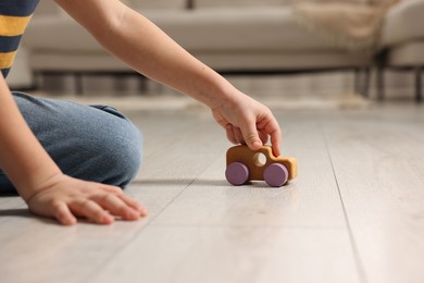 Photo of Little boy playing with toy car at home, closeup