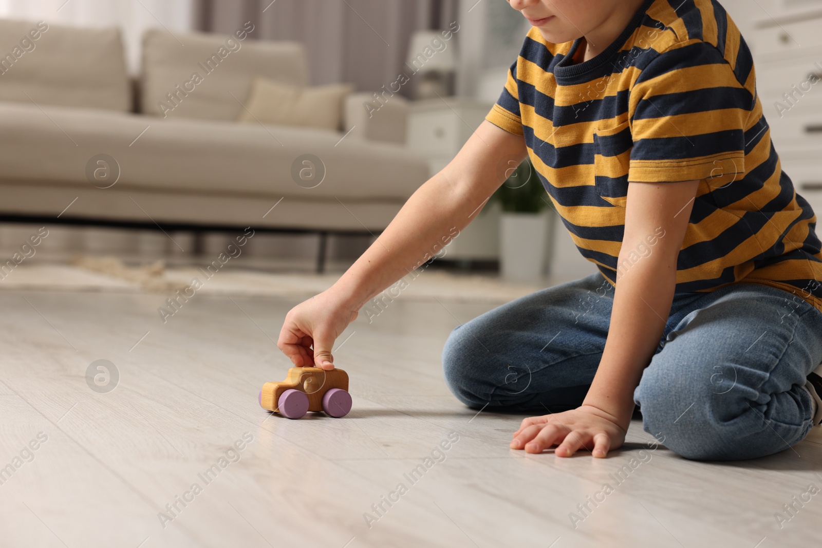 Photo of Little boy playing with toy car at home, closeup. Space for text