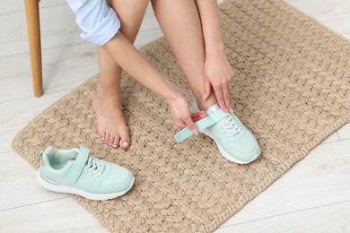 Photo of Woman changing into sneakers indoors, above view