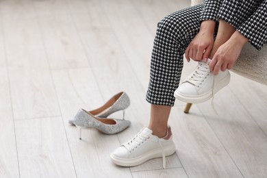 Photo of Woman changing shoes in armchair indoors, closeup. Space for text