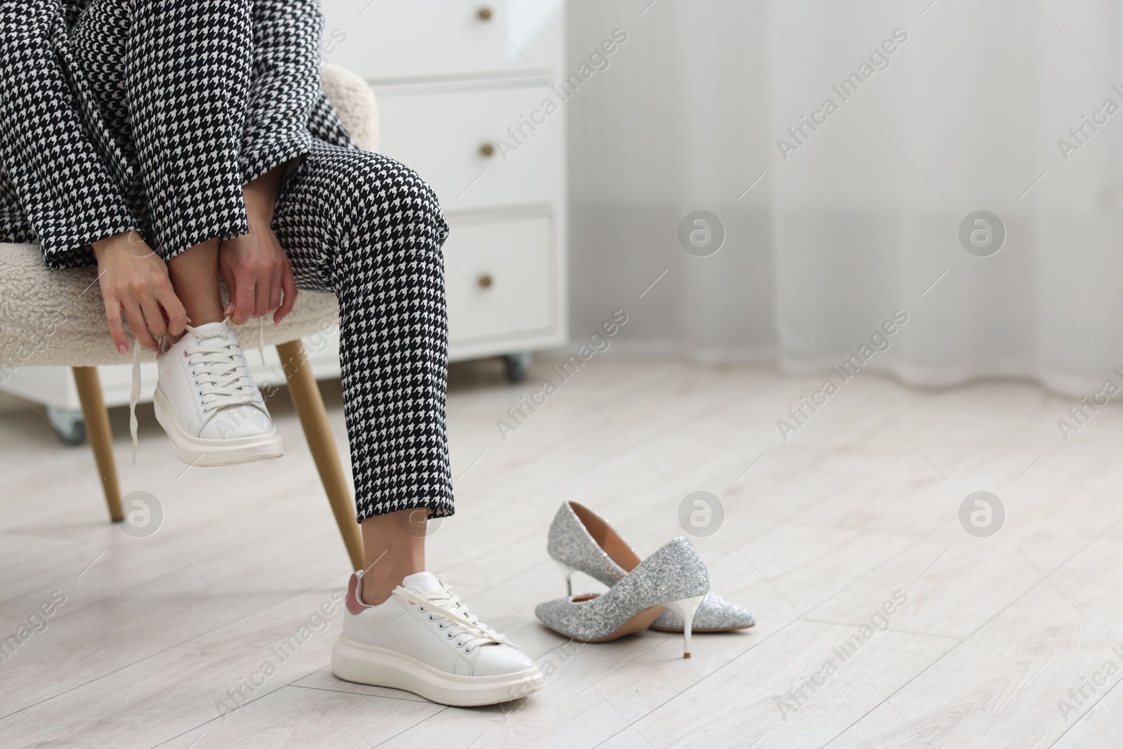 Photo of Woman changing shoes in armchair indoors, closeup. Space for text