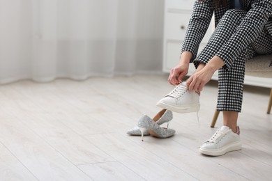 Photo of Woman changing shoes in armchair indoors, closeup. Space for text