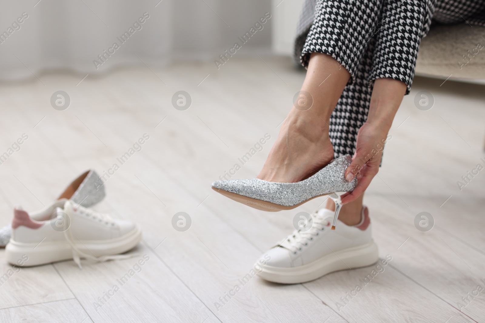 Photo of Woman changing shoes on chair indoors, closeup