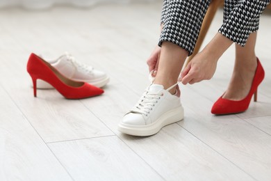 Photo of Woman changing shoes at home, closeup view