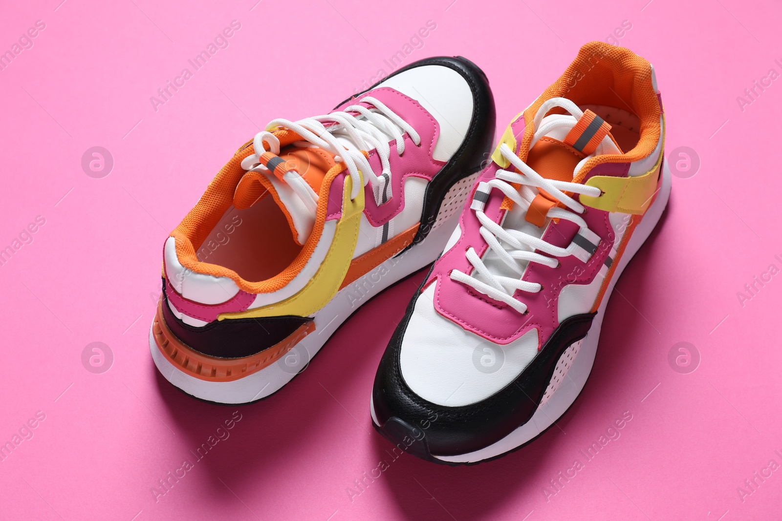 Photo of Pair of stylish sneakers on pink background, above view. Sportive shoes