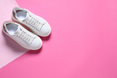 Photo of Sportive shoes. Pair of stylish sneakers on pink background, flat lay. Space for text