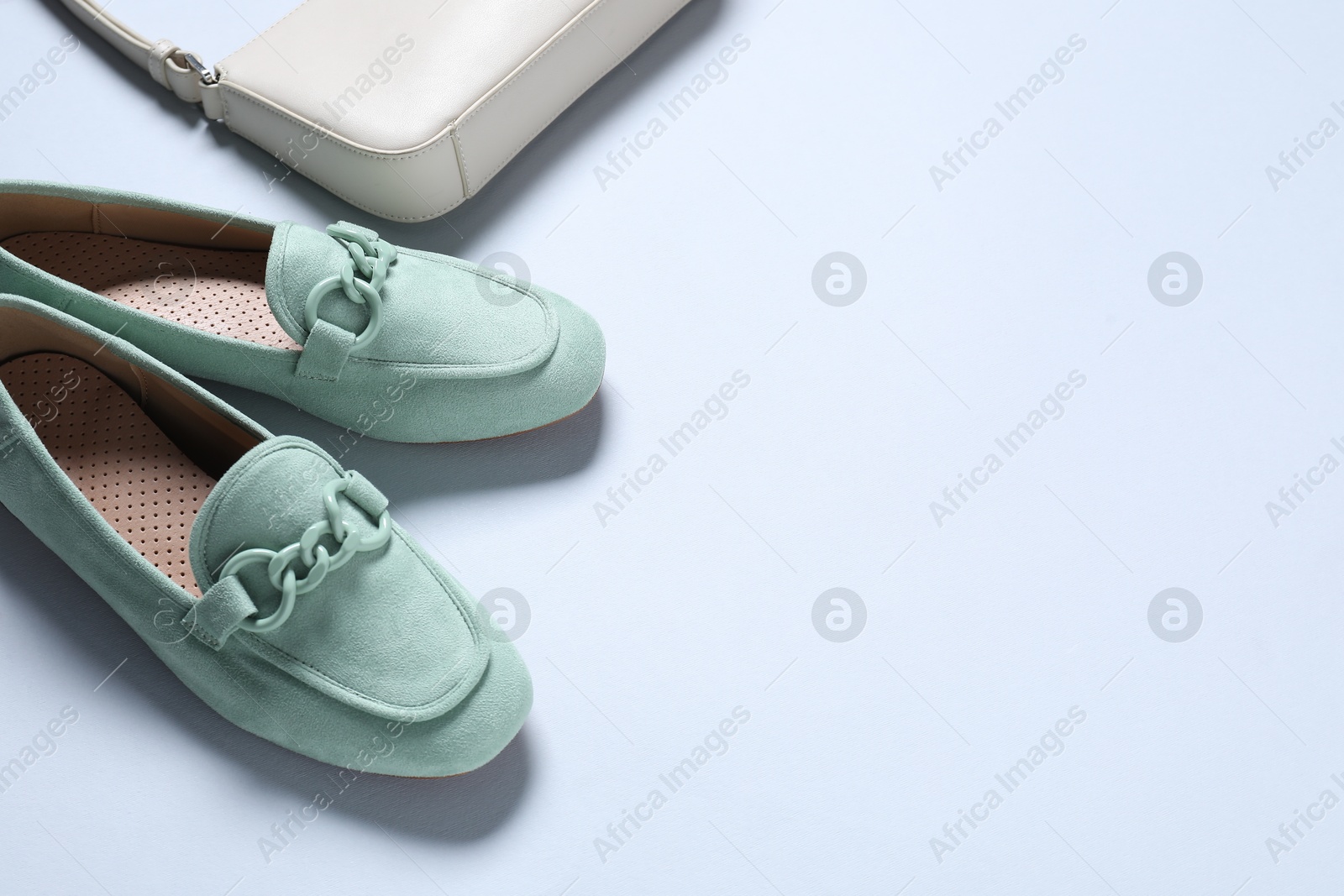 Photo of Pair of stylish shoes and bag on white background, above view. Space for text