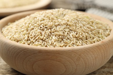 Photo of Brown rice in bowl on table, closeup