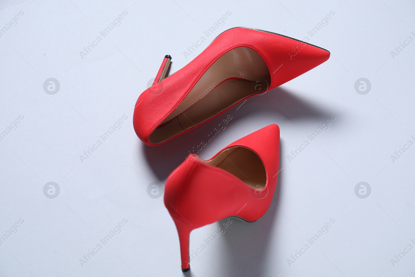 Photo of Pair of red high heeled shoes on white background, above view