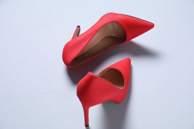 Photo of Pair of red high heeled shoes on white background, above view