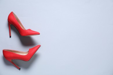 Photo of Pair of red high heeled shoes on white background, flat lay. Space for text