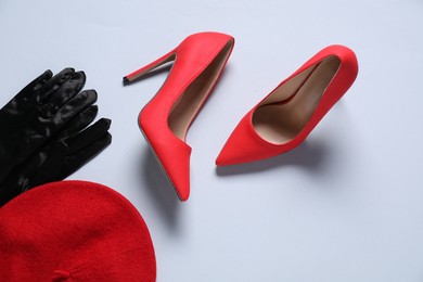 Photo of Pair of red high heeled shoes, gloves and beret on white background, flat lay