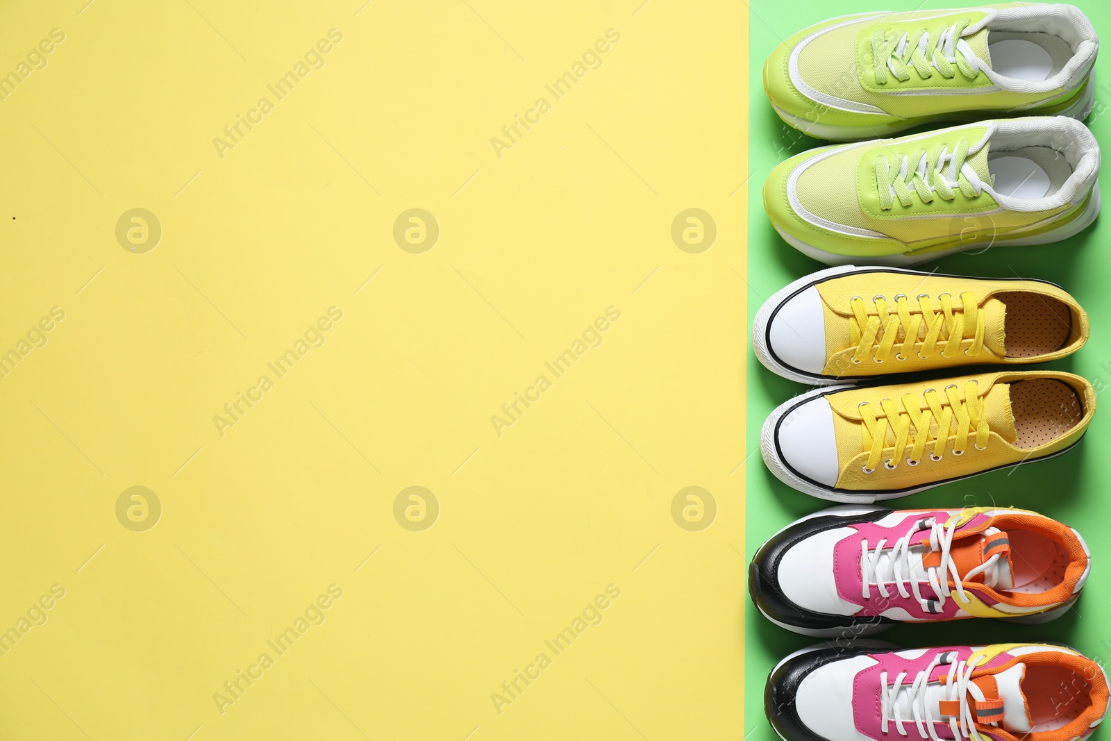 Photo of Sportive shoes. Different sneakers on color background, flat lay. Space for text