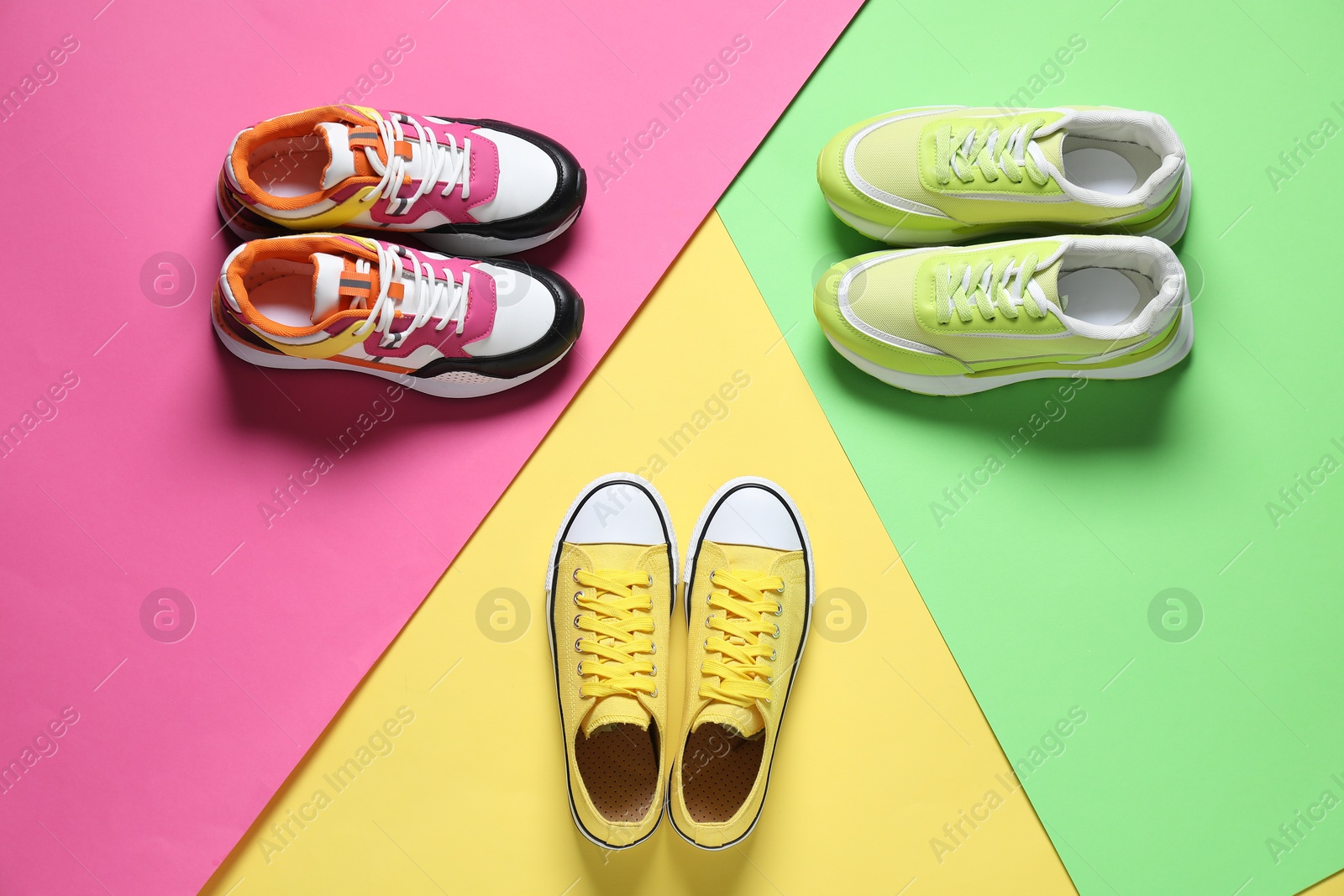 Photo of Different sneakers on color background, flat lay. Sportive shoes