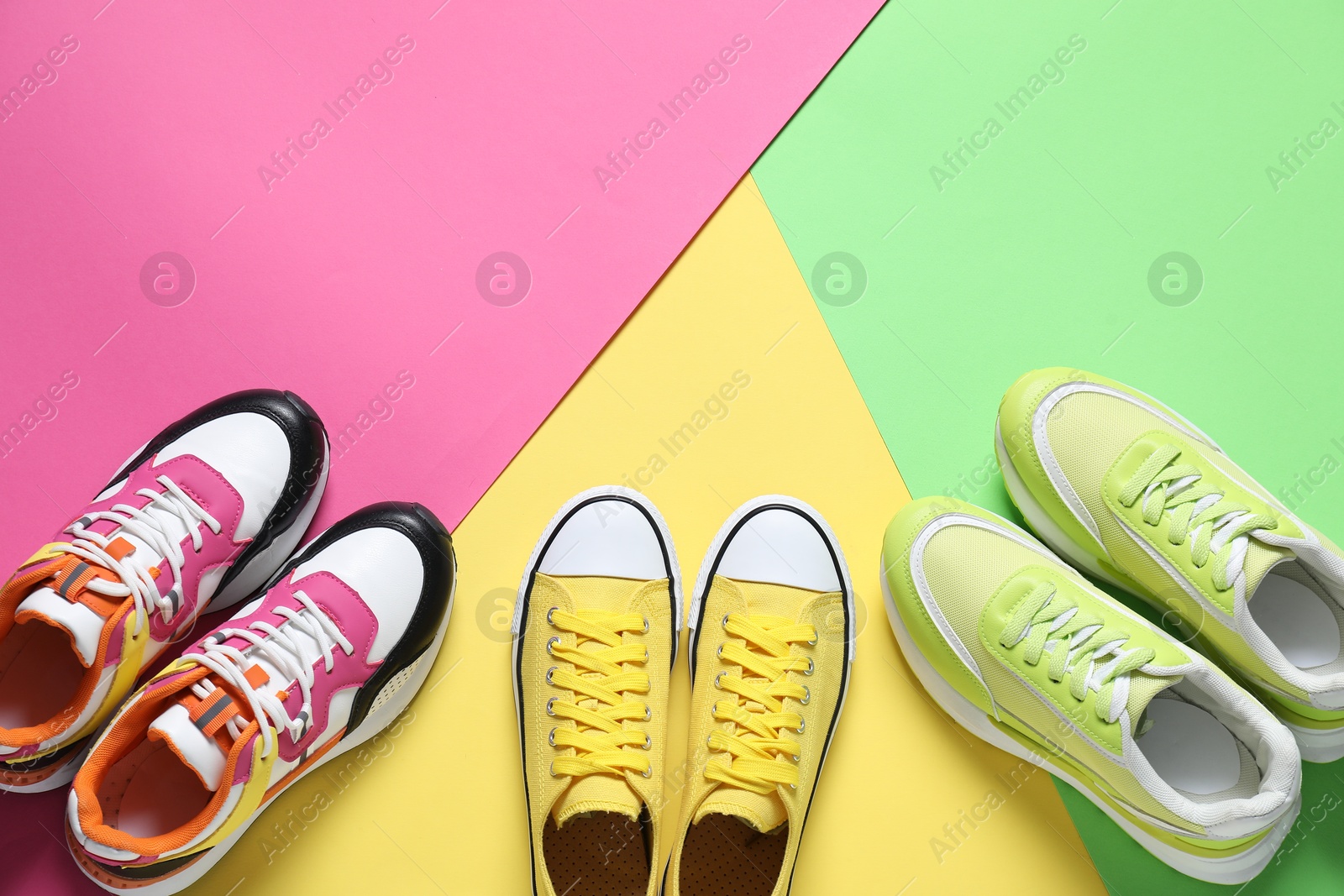 Photo of Sportive shoes. Different sneakers on color background, flat lay. Space for text