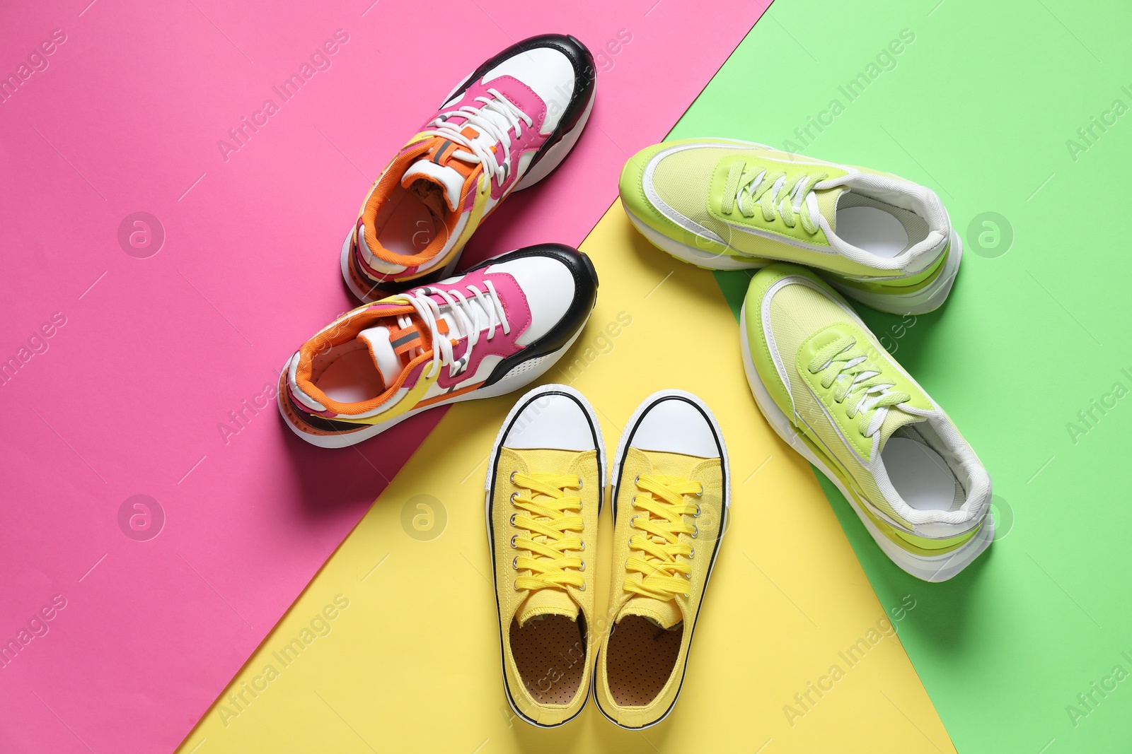 Photo of Different sneakers on color background, flat lay. Sportive shoes