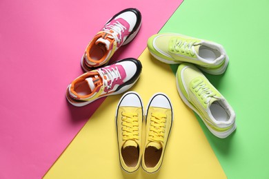 Photo of Different sneakers on color background, flat lay. Sportive shoes