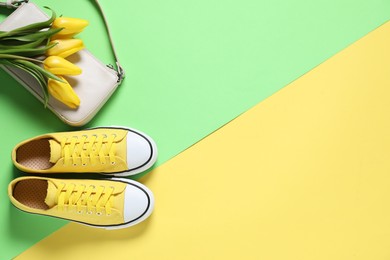 Photo of Stylish shoes, bag and yellow tulips on color background, flat lay. Space for text