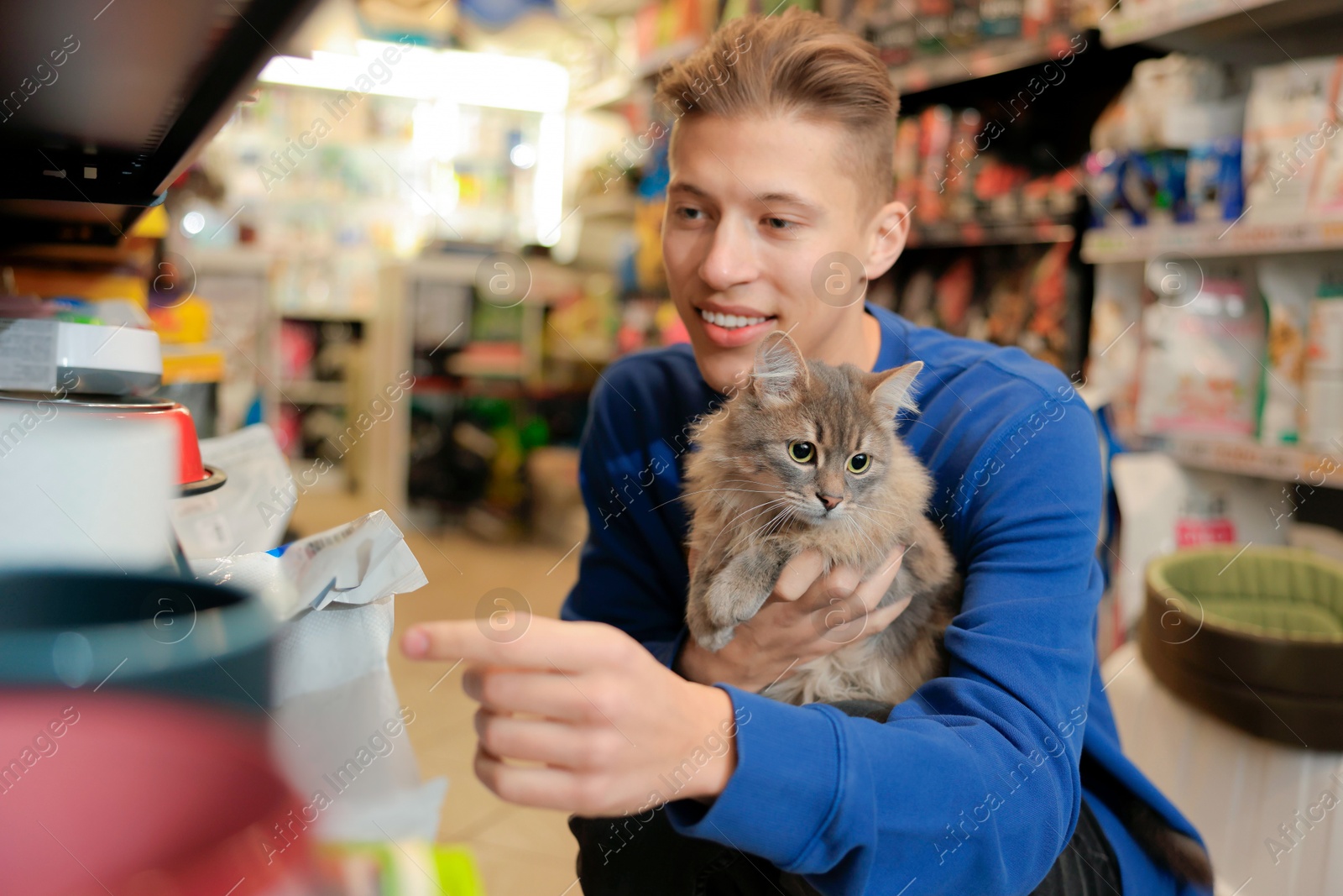 Photo of Man with his cute cat in pet shop