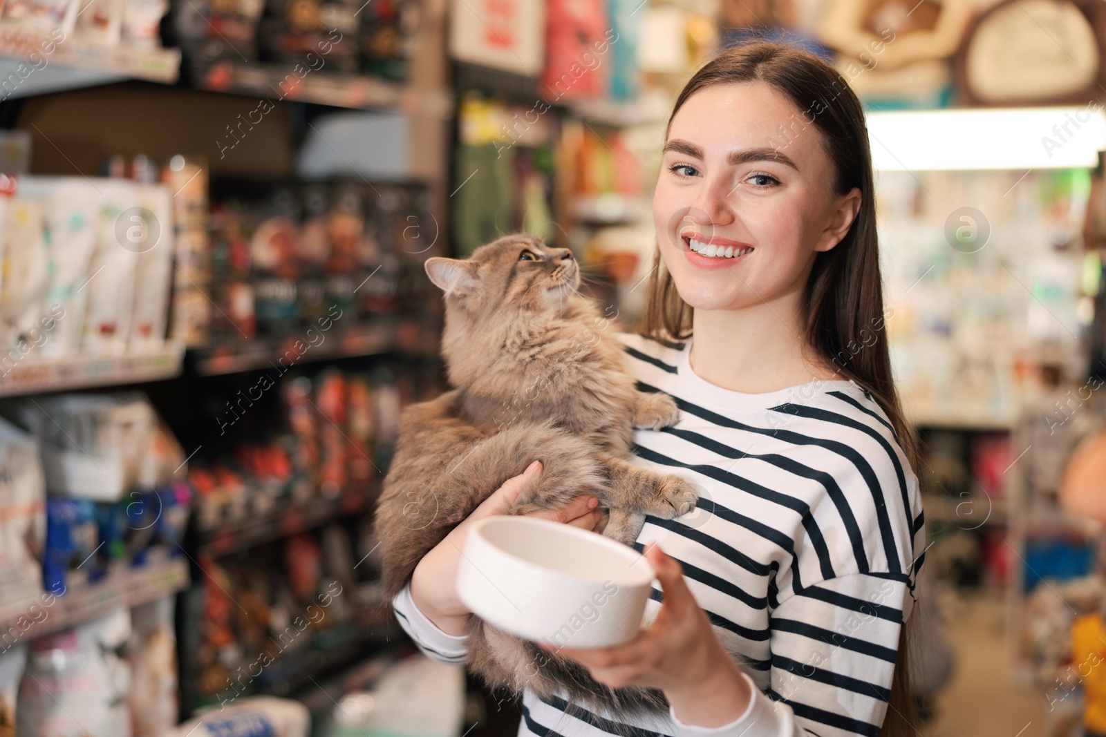 Photo of Woman with her cute cat and feeding bowl in pet shop. Space for text