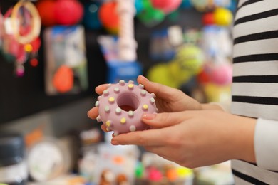 Photo of Woman with rubber toy in pet shop, closeup