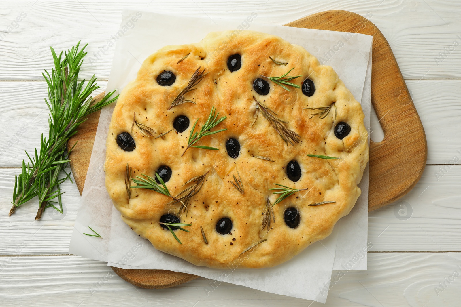 Delicious focaccia bread with olives and rosemary on white wooden table, top view Photo of Delicious focaccia bread with olives and rosemary on white wooden table, top view