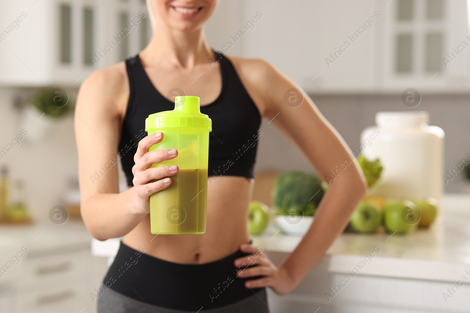 Photo of Weight loss. Woman with shaker of protein in kitchen, closeup