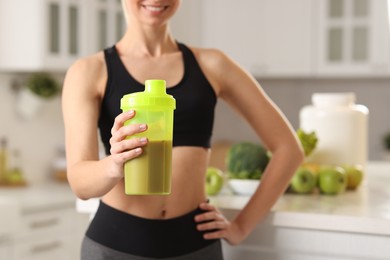 Photo of Weight loss. Woman with shaker of protein in kitchen, closeup