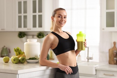 Photo of Weight loss. Happy woman with shaker of protein in kitchen