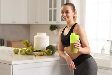 Photo of Weight loss. Happy woman with shaker of protein in kitchen