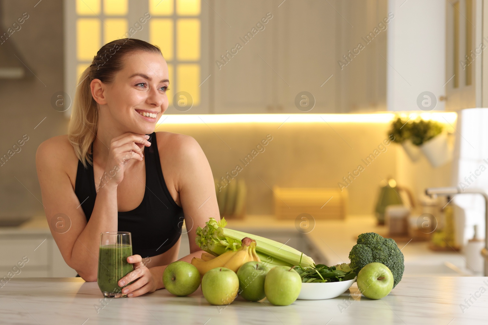 Photo of Weight loss. Happy woman with healthy shake at white marble table in kitchen