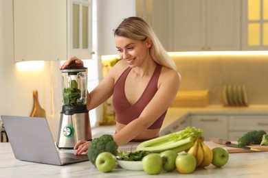 Photo of Weight loss. Woman making protein shake at table in kitchen