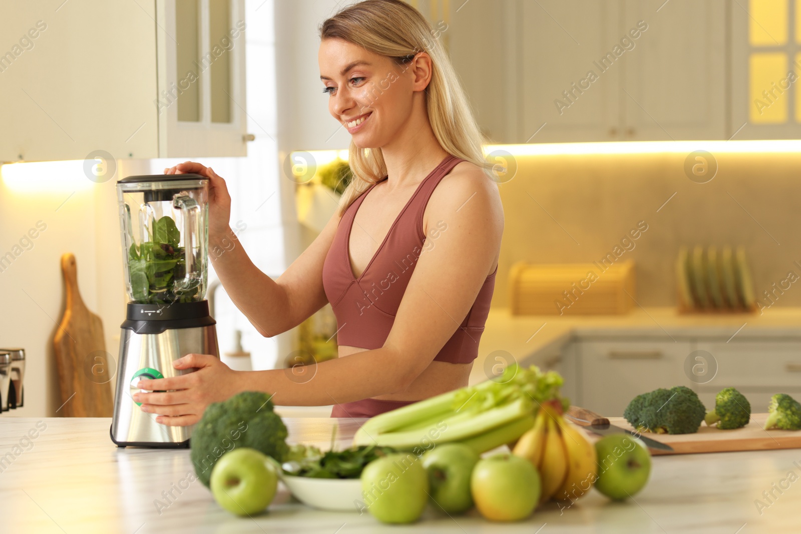 Photo of Weight loss. Woman making protein shake at table in kitchen