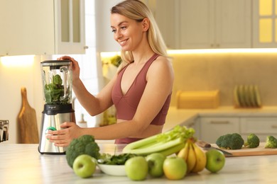 Photo of Weight loss. Woman making protein shake at table in kitchen