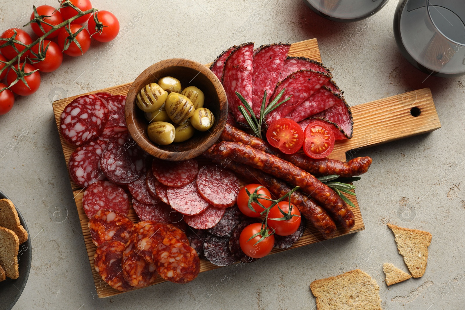 Photo of Different smoked sausages slices served on light table, flat lay