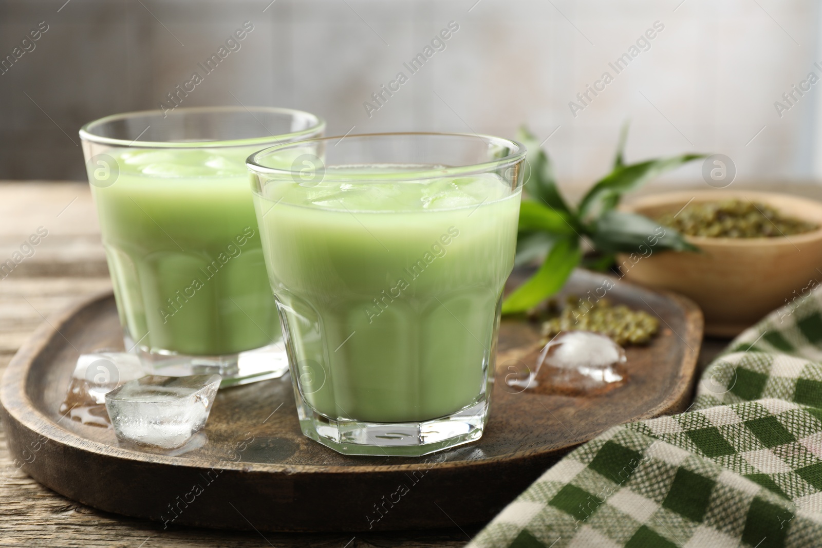 Fresh mung bean juice with ice in glasses on wooden table, closeup Photo of Fresh mung bean juice with ice in glasses on wooden table, closeup