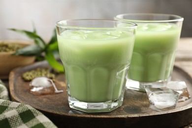 Photo of Fresh mung bean juice with ice in glasses on table, closeup