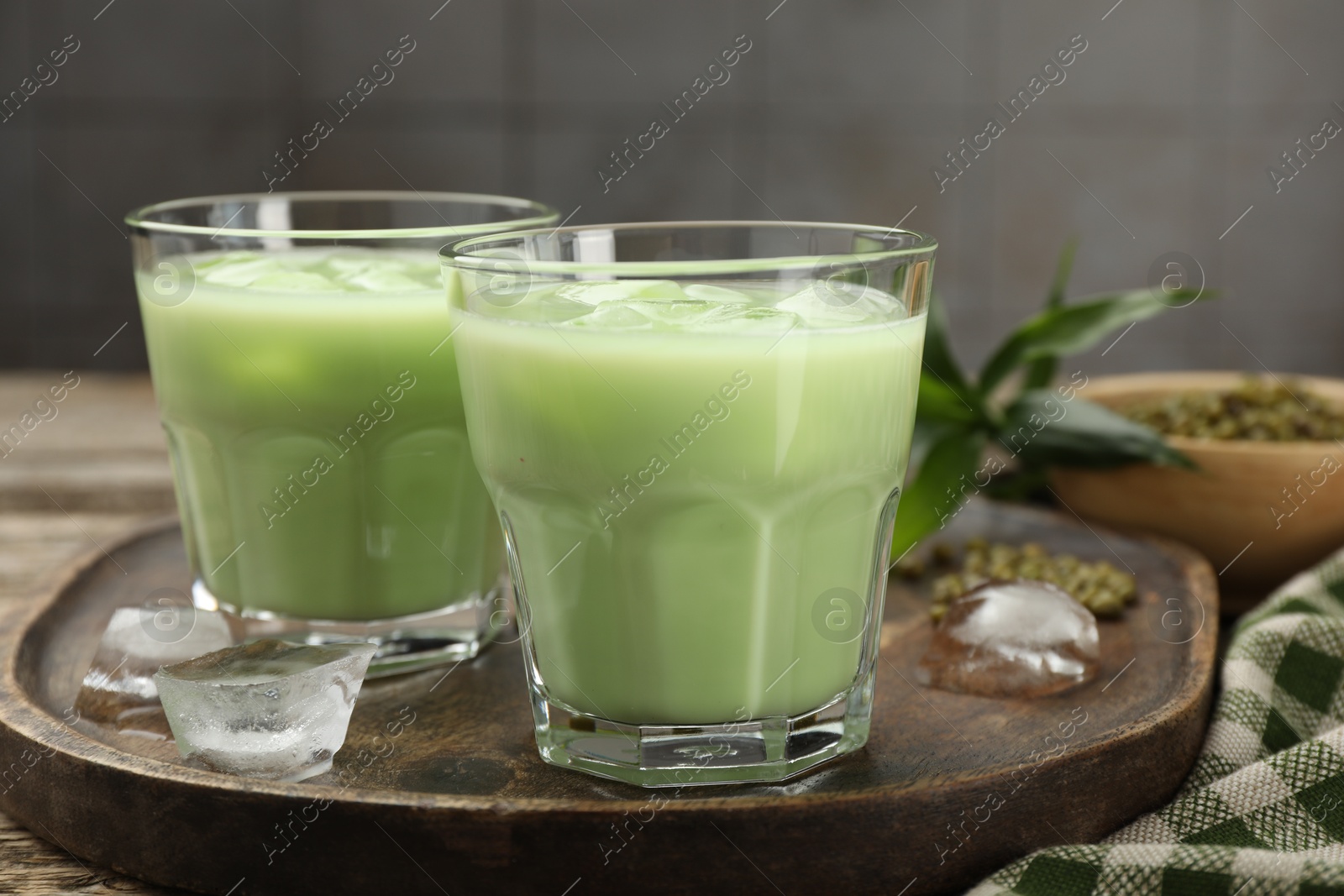 Fresh mung bean juice with ice in glasses on wooden table, closeup Photo of Fresh mung bean juice with ice in glasses on wooden table, closeup