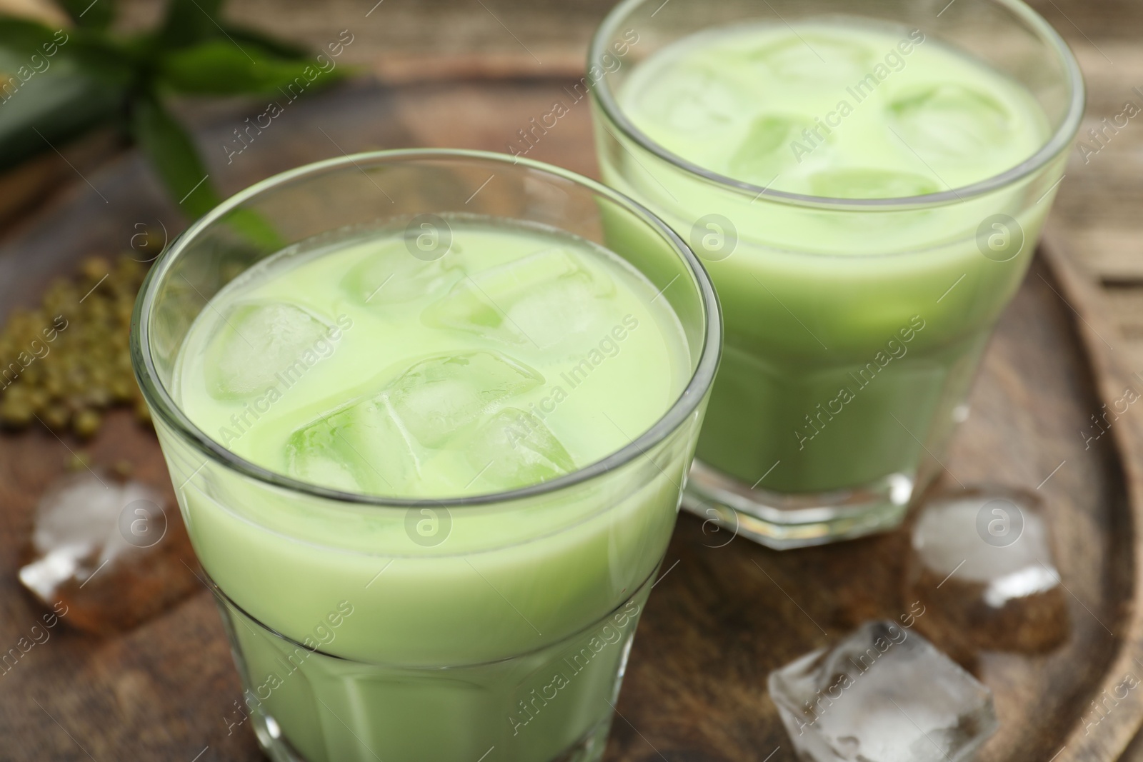 Fresh mung bean juice with ice in glasses on wooden table, closeup Photo of Fresh mung bean juice with ice in glasses on wooden table, closeup