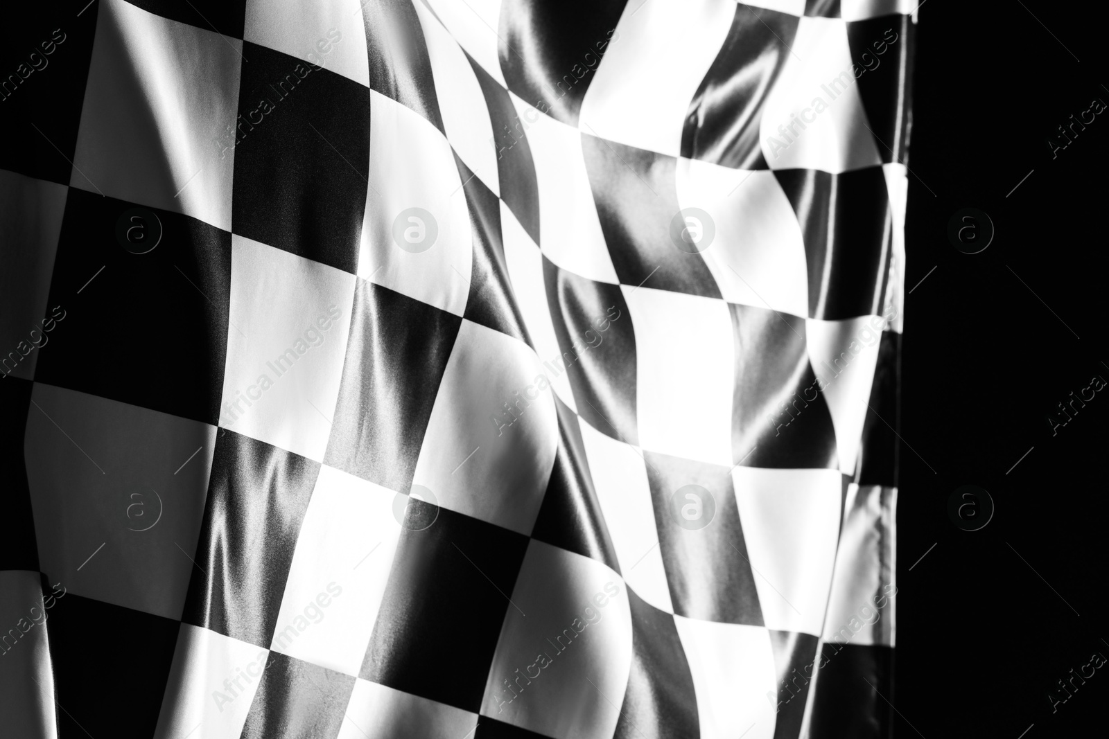 Photo of One racing checkered flag on black background, closeup