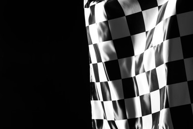 Photo of One racing checkered flag on black background, space for text