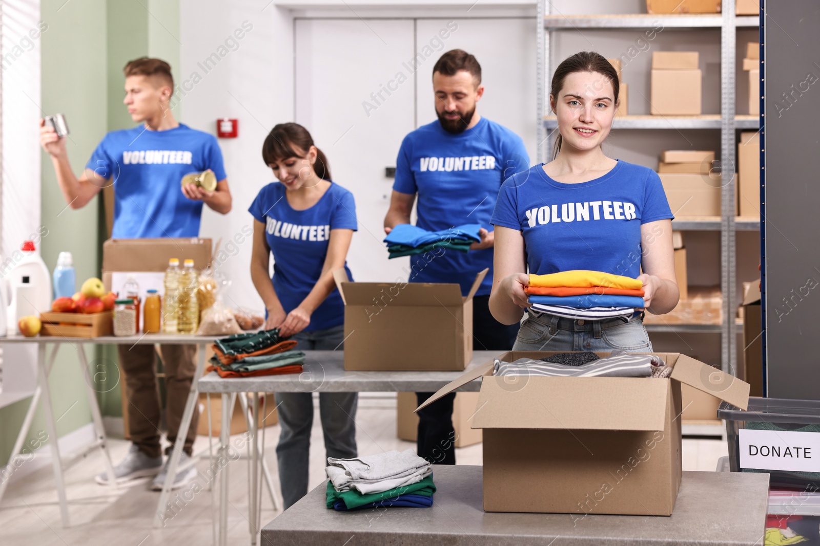 Photo of Group of volunteers packing donation goods at tables indoors