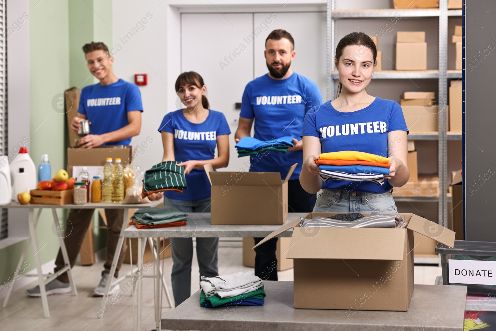 Photo of Group of volunteers packing donation goods at tables indoors