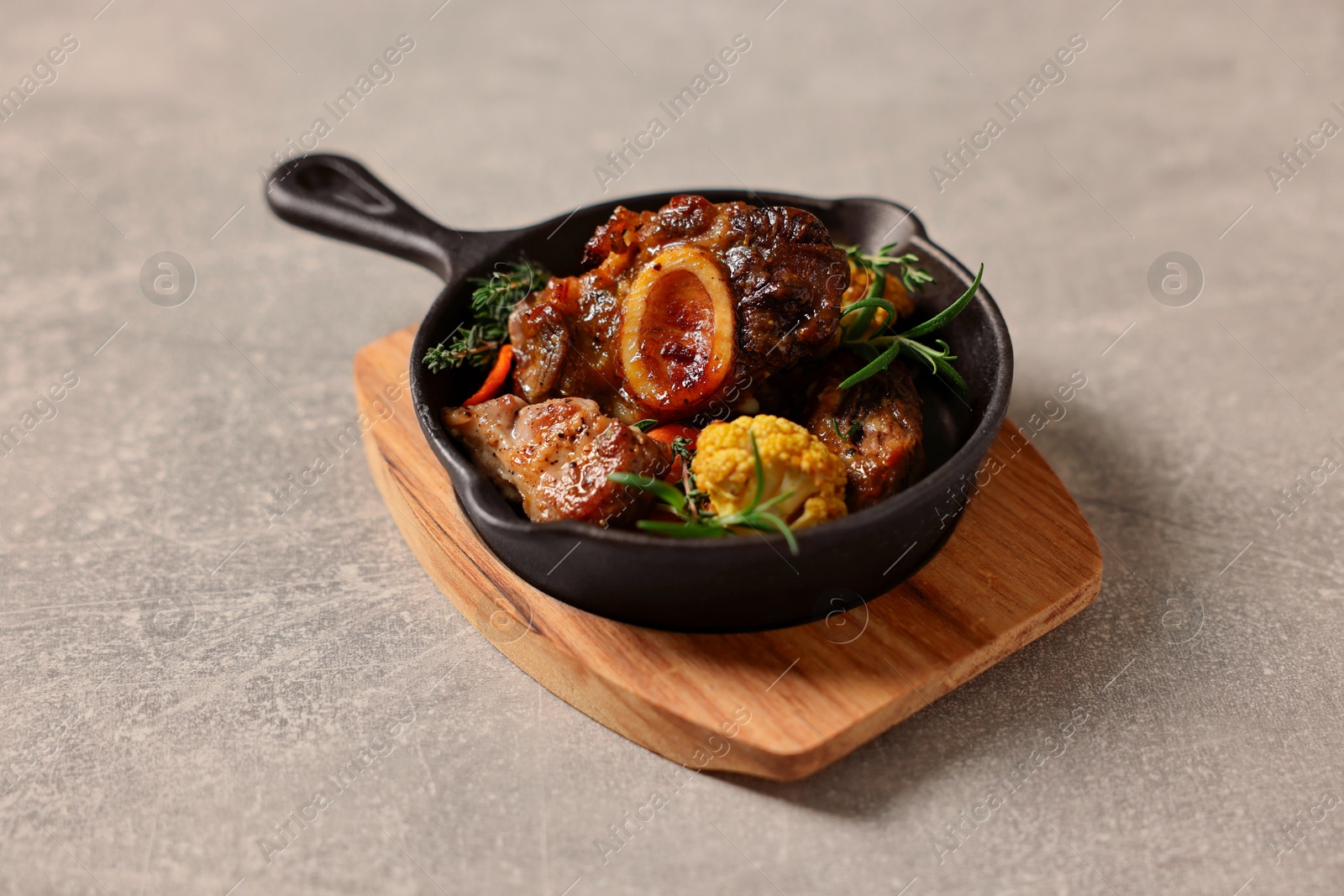 Photo of Delicious grilled meat and vegetables served on light grey table