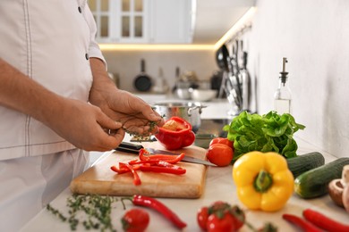 Photo of Professional chef with fresh products at counter in kitchen, closeup