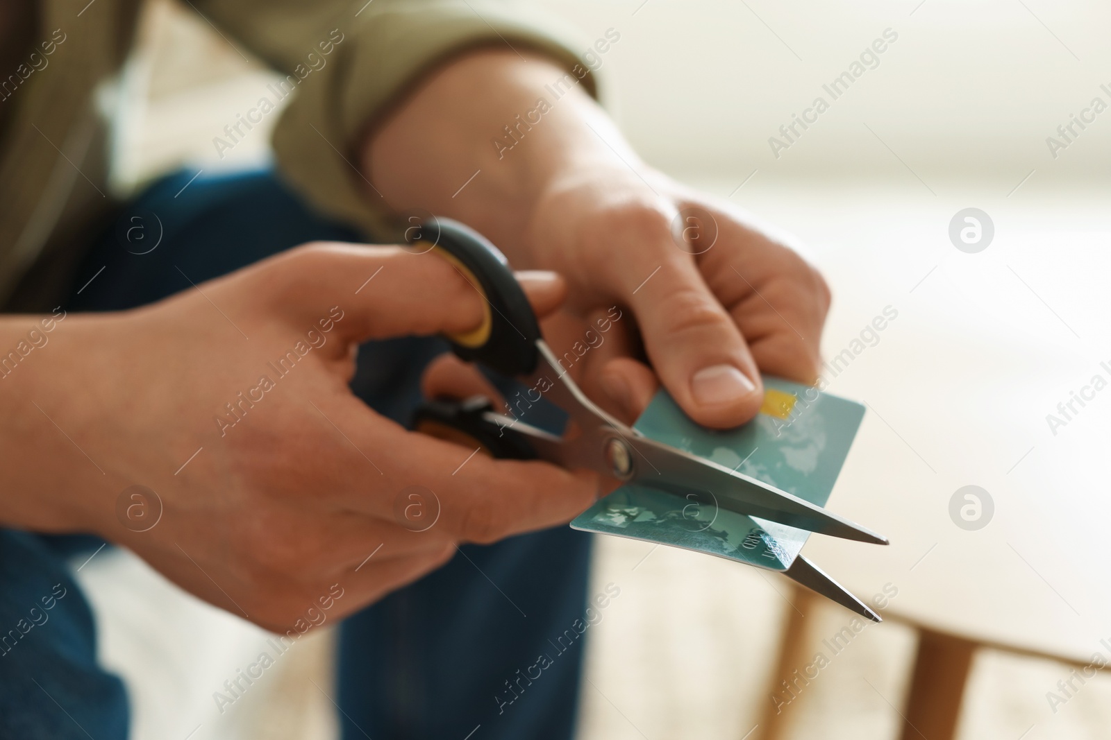 Photo of Man cutting his credit card indoors, closeup