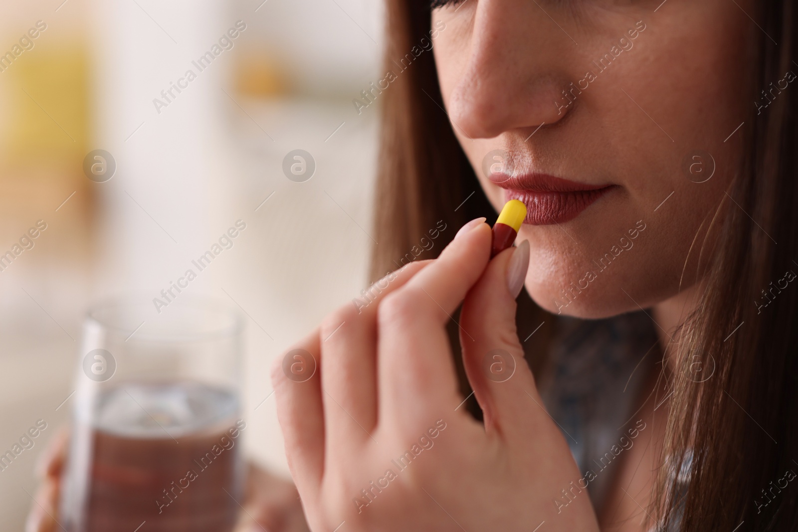 Photo of Woman taking medical pill at home, closeup